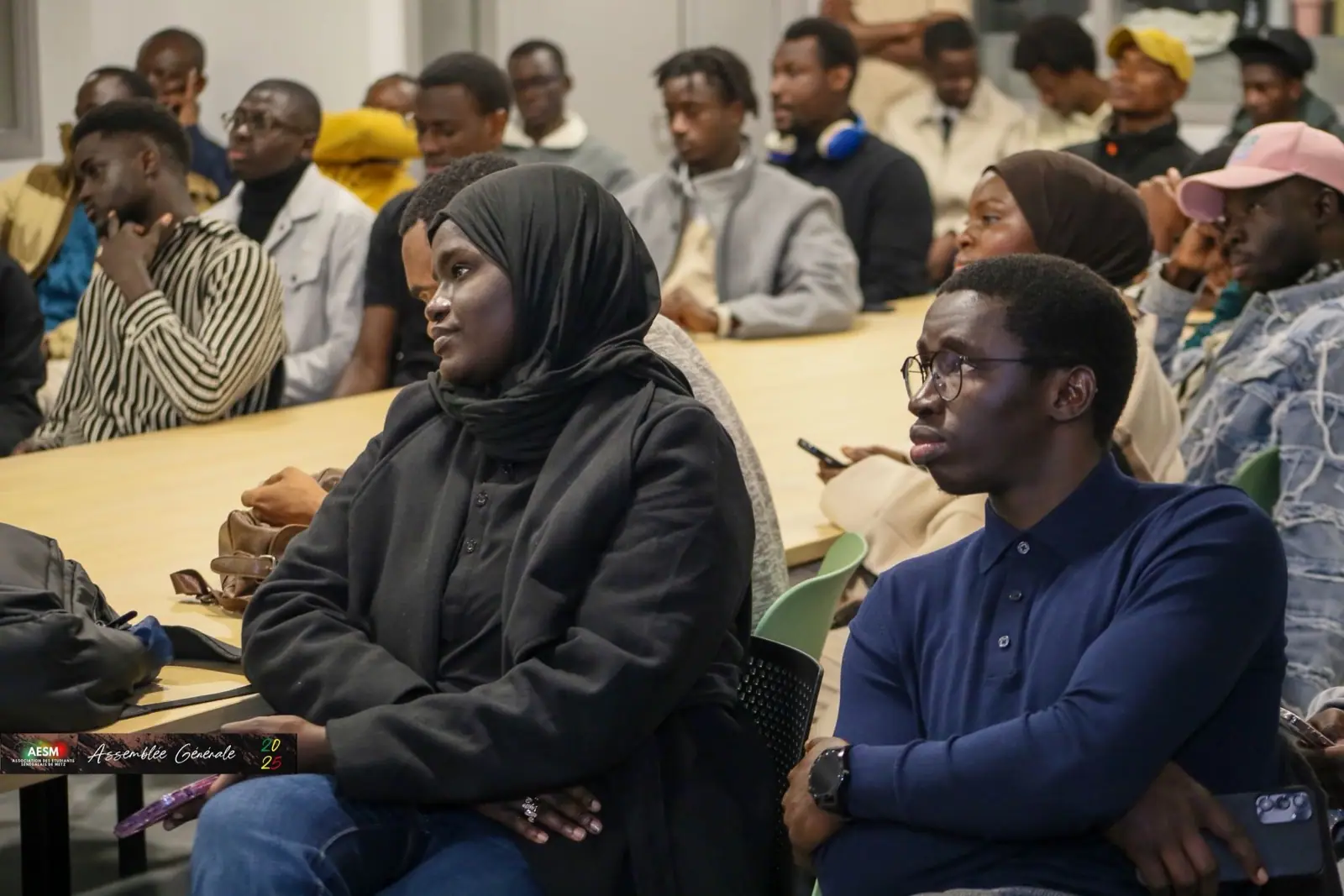 Étudiants assis et attentifs pendant une assemblée générale de l'AESM